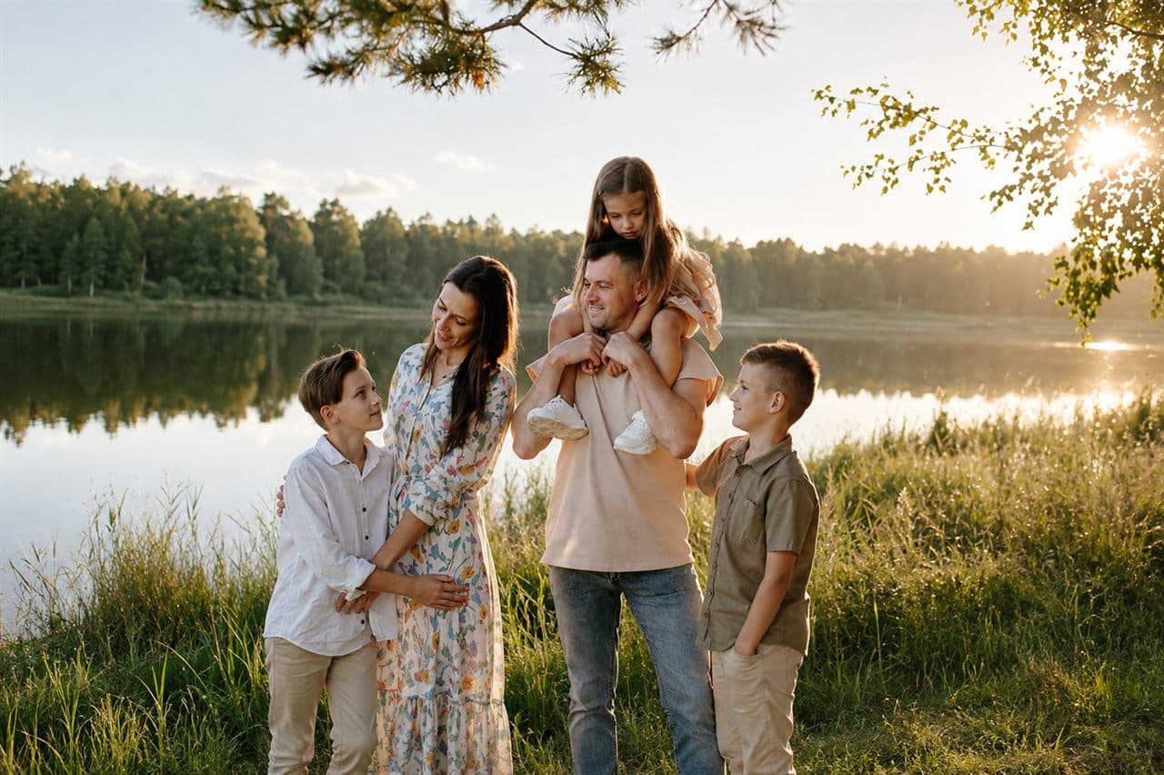 Familia al atardecer junto a un lago, acompañada por AMR Consultores